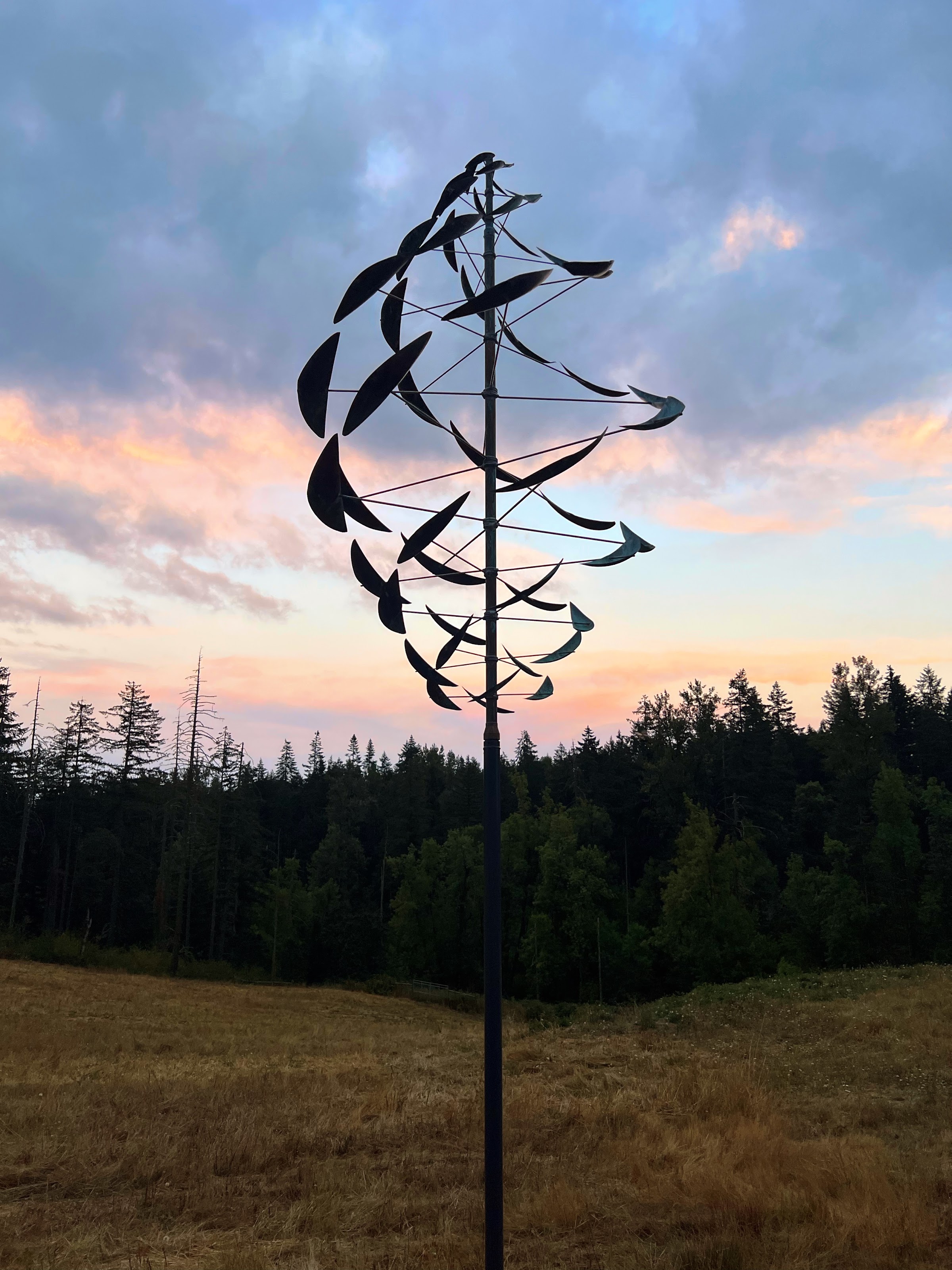 Double Dancer, kinetic wind sculpture by Lyman Whitaker, silhouetted at sunset at Chaos Vineyard