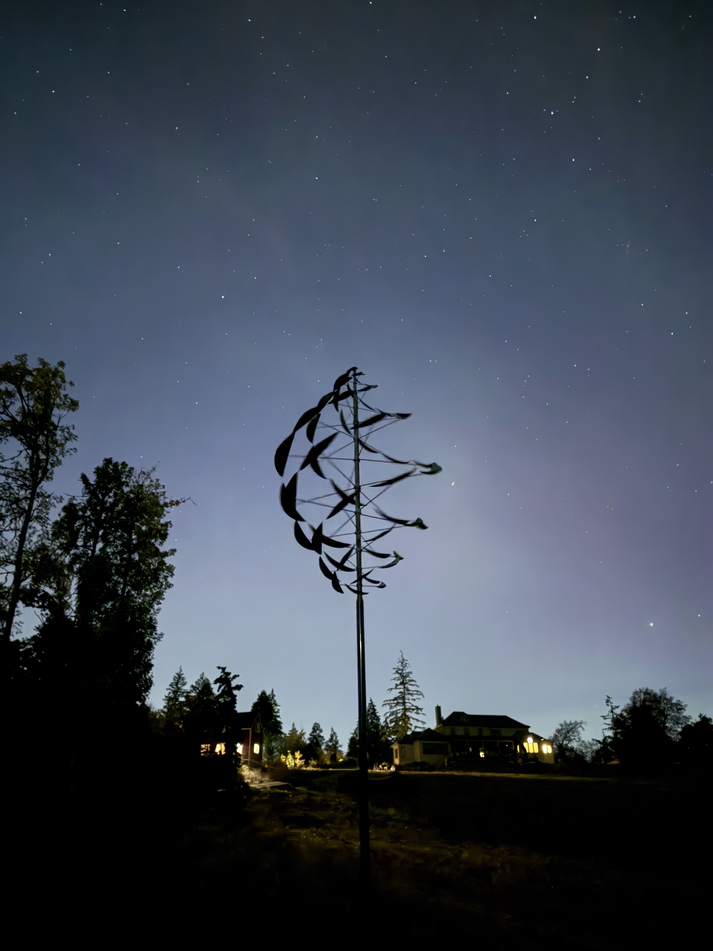 Double Dancer, kinetic wind sculpture by Lyman Whitaker, silhouetted at night under the stars at Chaos Vineyard